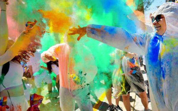 People covered in colored paint at Holi Moli
